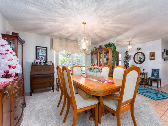 dining area with a chandelier, a textured ceiling, and light tile patterned flooring