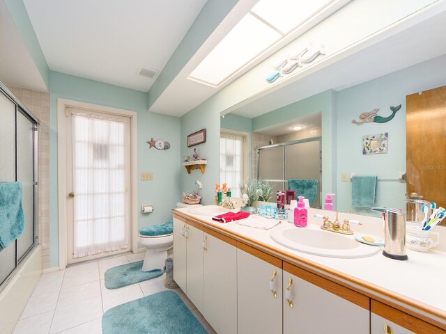 bathroom featuring tile patterned flooring, visible vents, toilet, a skylight, and vanity