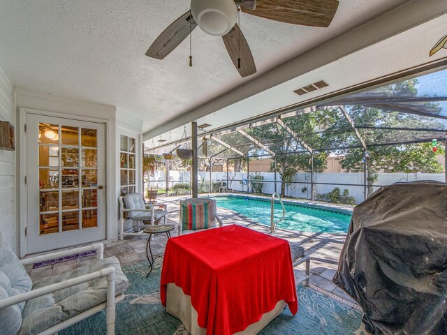 view of swimming pool featuring a fenced backyard, a lanai, a grill, ceiling fan, and a patio area