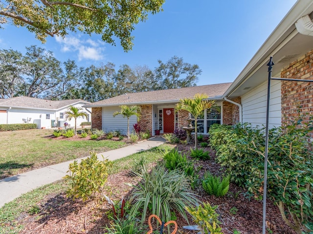 ranch-style home featuring brick siding and a front lawn