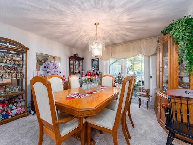 dining space with light carpet, a notable chandelier, and a textured ceiling