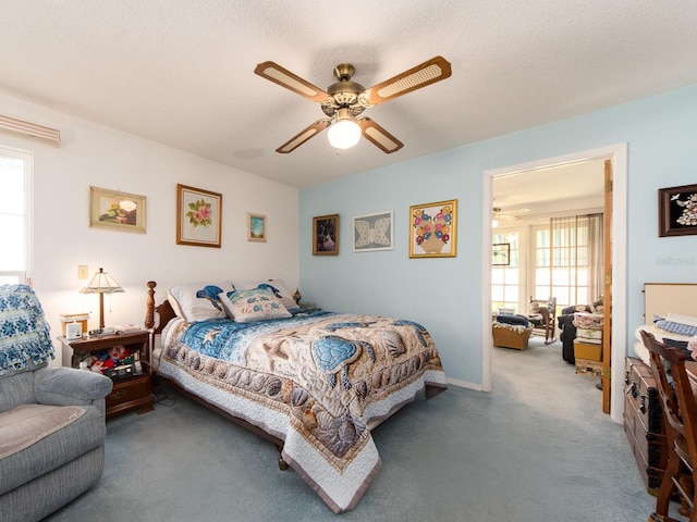 bedroom featuring a ceiling fan, carpet floors, and a textured ceiling