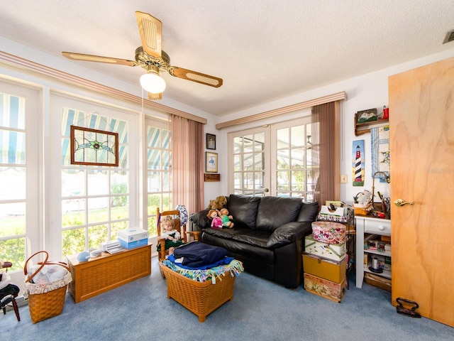 carpeted living room featuring visible vents, french doors, a textured ceiling, and ceiling fan