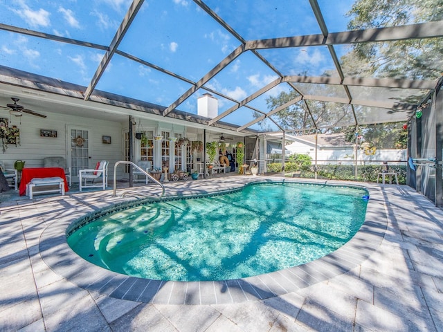 outdoor pool with a lanai, ceiling fan, and a patio