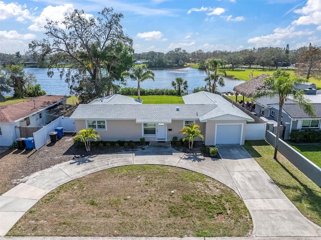 ranch-style house featuring a garage, a water view, and a front yard