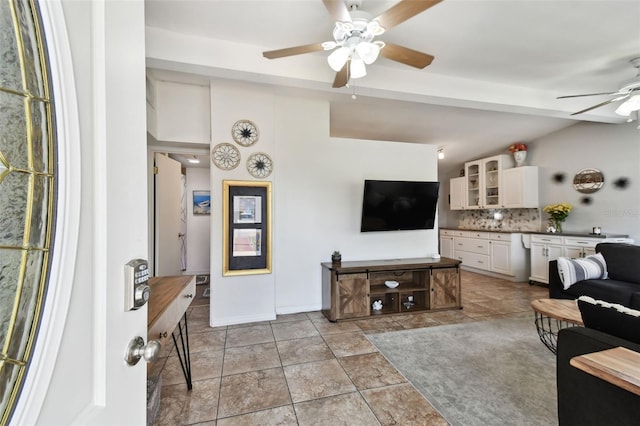 tiled living room with ceiling fan and vaulted ceiling with beams