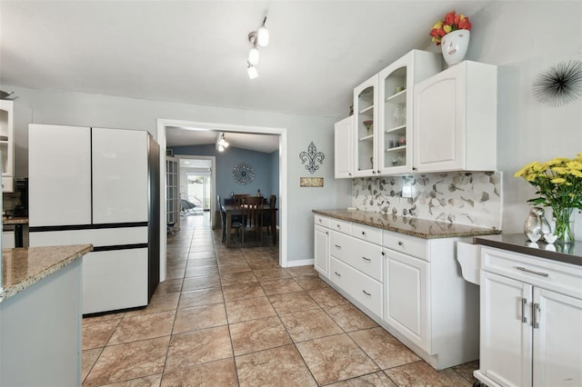 kitchen featuring white cabinetry, white fridge, light stone countertops, and decorative backsplash