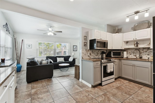 kitchen with tasteful backsplash, white cabinetry, appliances with stainless steel finishes, and a healthy amount of sunlight