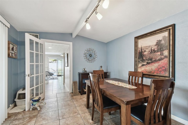 dining area with lofted ceiling with beams, light tile patterned flooring, rail lighting, and french doors