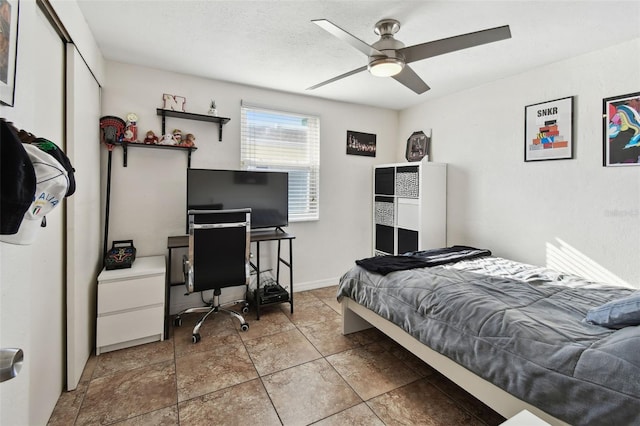 bedroom with ceiling fan, a closet, and a textured ceiling