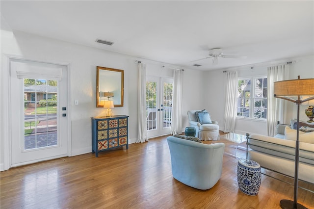 living area with french doors, ceiling fan, and wood-type flooring