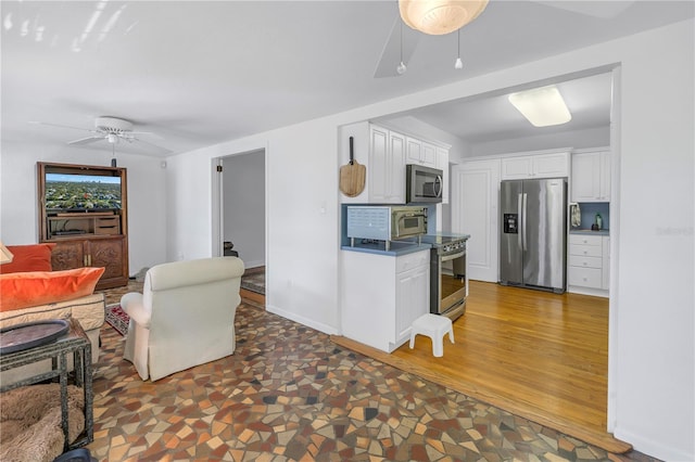 kitchen with ceiling fan, dark hardwood / wood-style floors, white cabinets, and appliances with stainless steel finishes