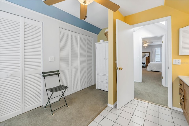 carpeted bedroom with vaulted ceiling, two closets, and ceiling fan