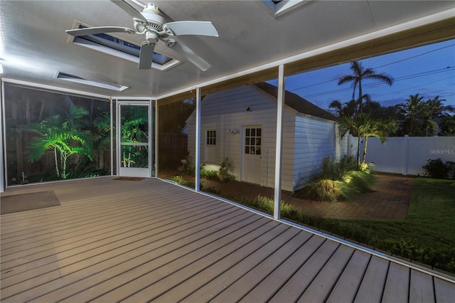 unfurnished sunroom featuring ceiling fan