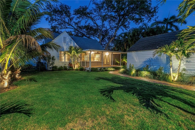 view of front of property featuring a sunroom and a front yard