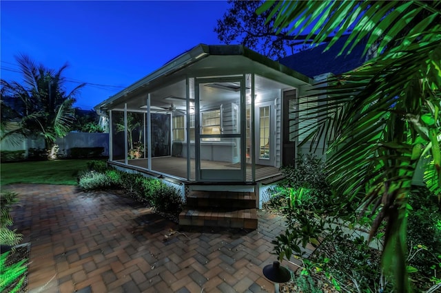 view of home's exterior with a patio area and a sunroom