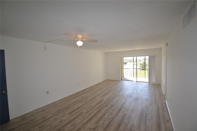 unfurnished room featuring visible vents, ceiling fan, and wood finished floors