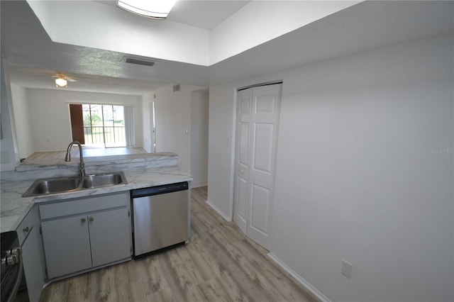 kitchen featuring visible vents, baseboards, appliances with stainless steel finishes, light wood-style floors, and a sink