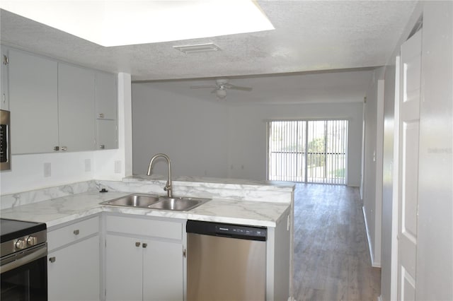 kitchen with visible vents, appliances with stainless steel finishes, open floor plan, a peninsula, and a sink