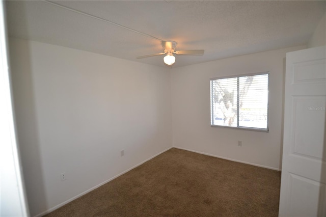 carpeted empty room with a ceiling fan and baseboards