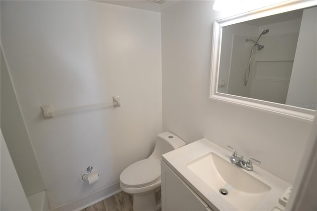 bathroom featuring vanity, walk in shower, and toilet