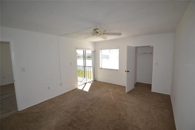 carpeted empty room with a ceiling fan