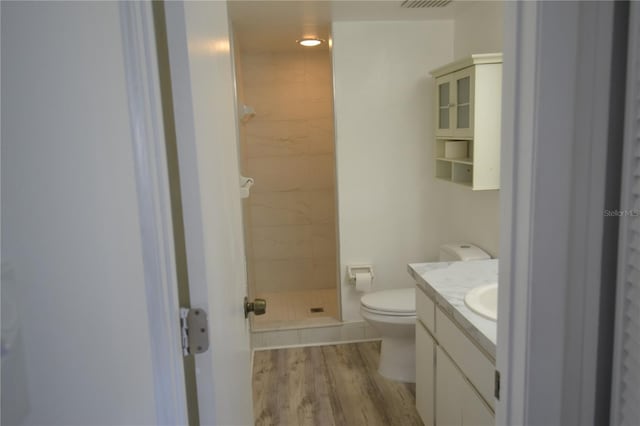 full bathroom featuring visible vents, toilet, a stall shower, vanity, and wood finished floors