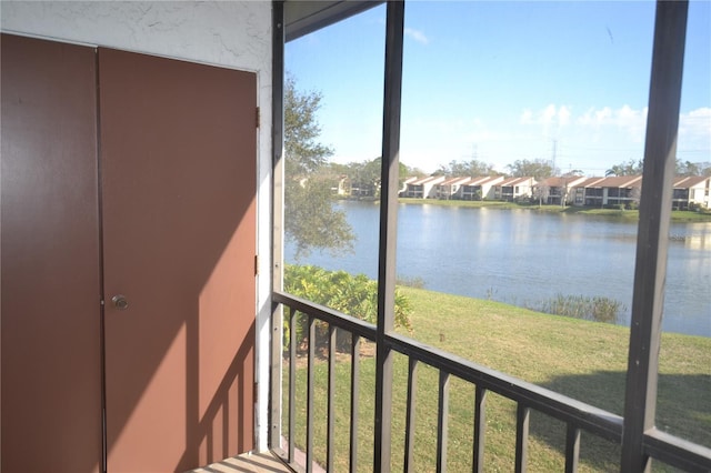 unfurnished sunroom with a residential view, a healthy amount of sunlight, and a water view