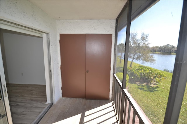 unfurnished sunroom featuring a water view