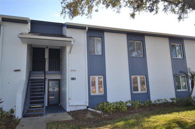 view of front of home with stairway and stucco siding