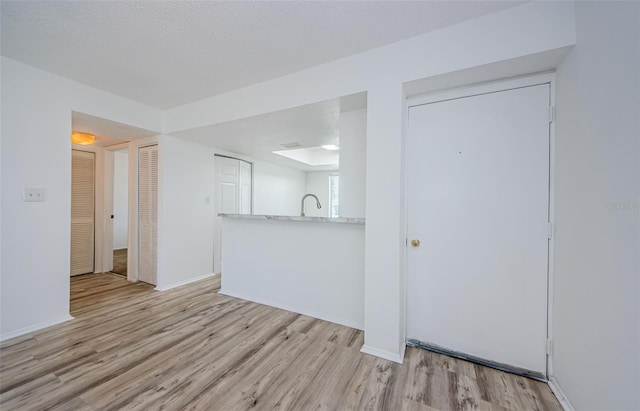 256 Cypress Ln Unit 120, Oldsmar, FL 34677 - unfurnished living room with light wood-style floors, baseboards, and a sink