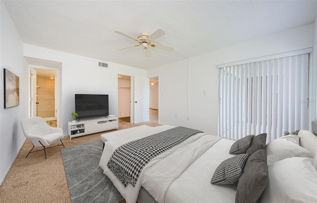 256 Cypress Ln Unit 120, Oldsmar, FL 34677 - carpeted bedroom with ceiling fan, a textured ceiling, and a walk in closet