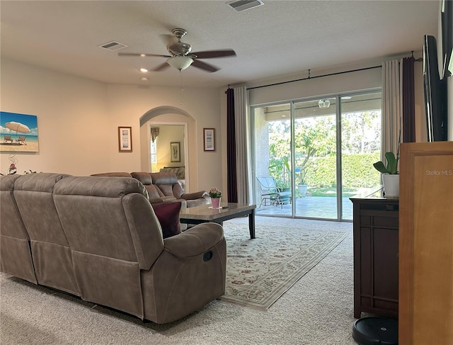 living room featuring carpet flooring, a textured ceiling, and ceiling fan