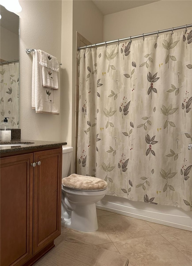 full bathroom with tile patterned floors, vanity, toilet, and shower / bath combo with shower curtain