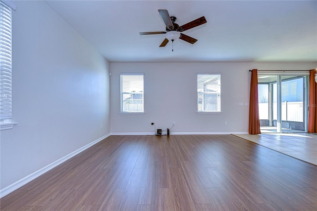 unfurnished room with ceiling fan, plenty of natural light, and wood-type flooring