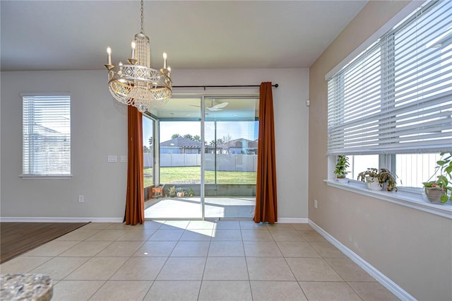 unfurnished dining area with light tile patterned floors and an inviting chandelier