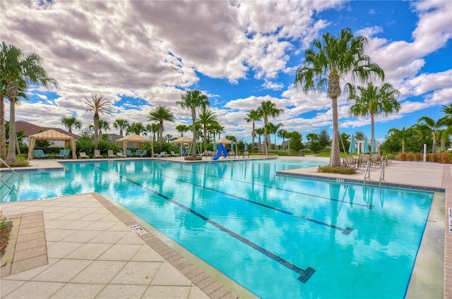 view of swimming pool featuring a gazebo, a water slide, and a patio area