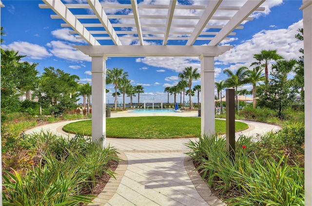 view of property's community featuring a swimming pool, a pergola, and a lawn