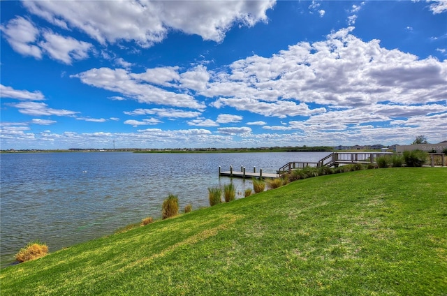 dock area with a water view and a yard