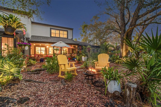 rear view of house with an outdoor fire pit