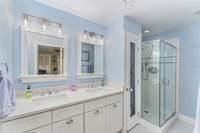 bathroom featuring vanity, tile patterned floors, a textured ceiling, and walk in shower