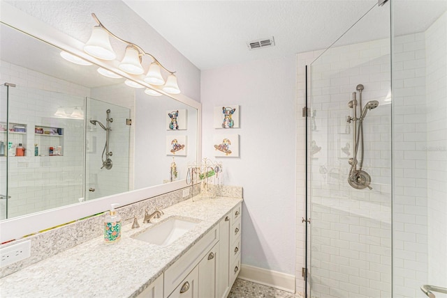 bathroom featuring vanity, a shower with door, and a textured ceiling