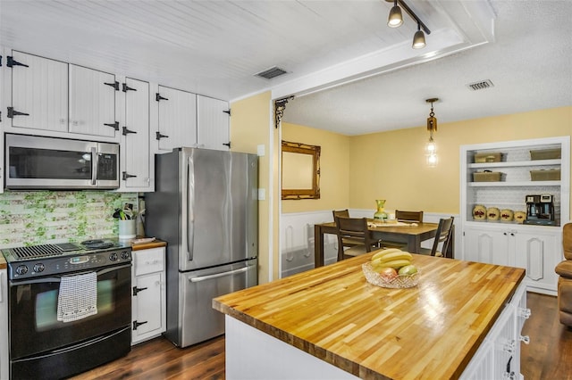 kitchen with pendant lighting, dark hardwood / wood-style floors, butcher block counters, and appliances with stainless steel finishes