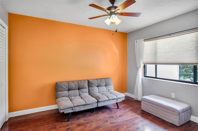 sitting room featuring ceiling fan, hardwood / wood-style floors, and a textured ceiling