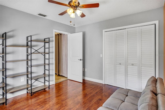 sitting room with hardwood / wood-style flooring, a textured ceiling, and ceiling fan