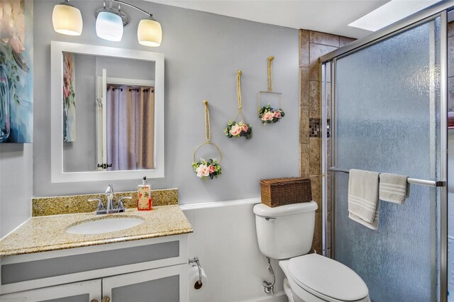 bathroom with walk in shower, vanity, and toilet