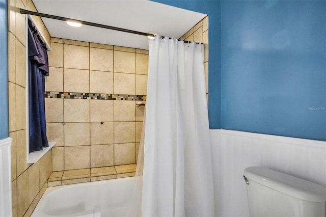 bathroom with shower / tub combo with curtain and toilet