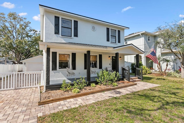 view of front of home featuring a garage, an outdoor structure, covered porch, and a front yard