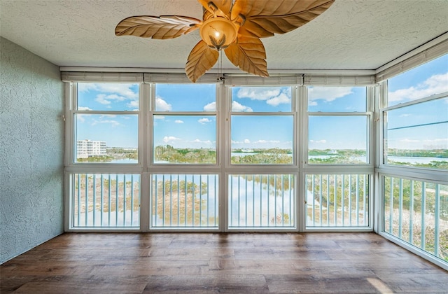 unfurnished sunroom with ceiling fan