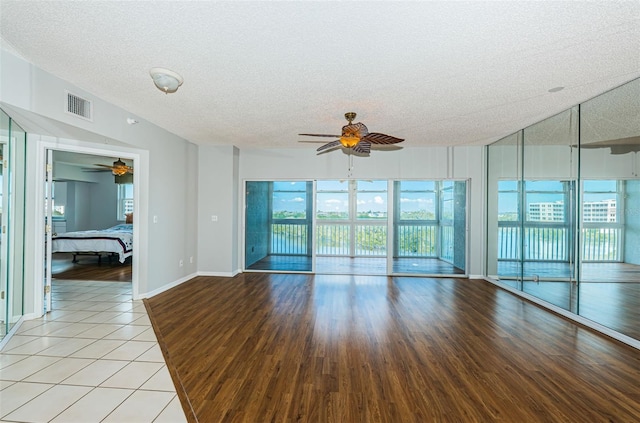 spare room with visible vents, ceiling fan, a textured ceiling, and light tile patterned floors